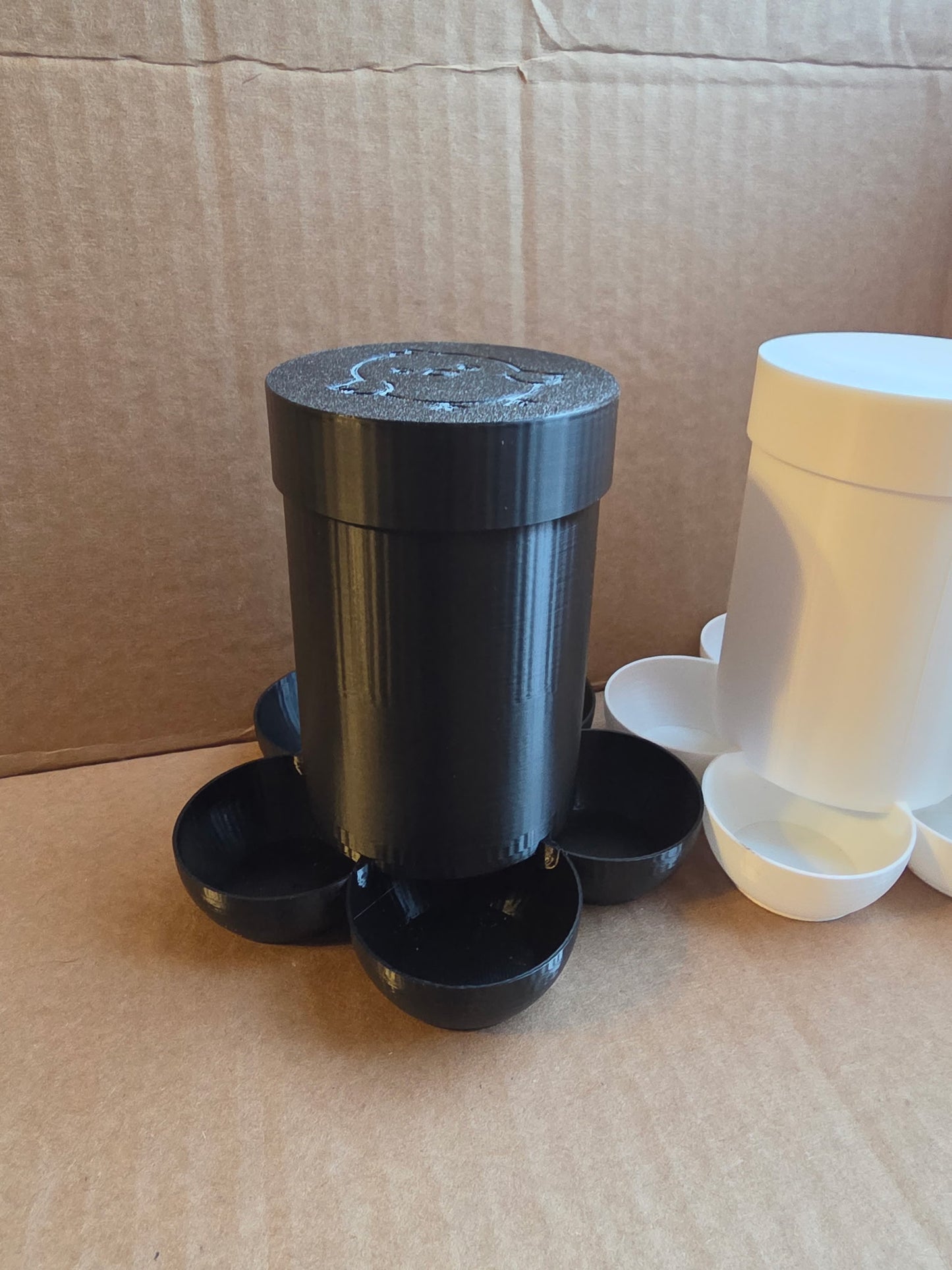 HoneyBunny3D small chick feeder with a clear plastic container and metal feeding tray for poultry chicks.