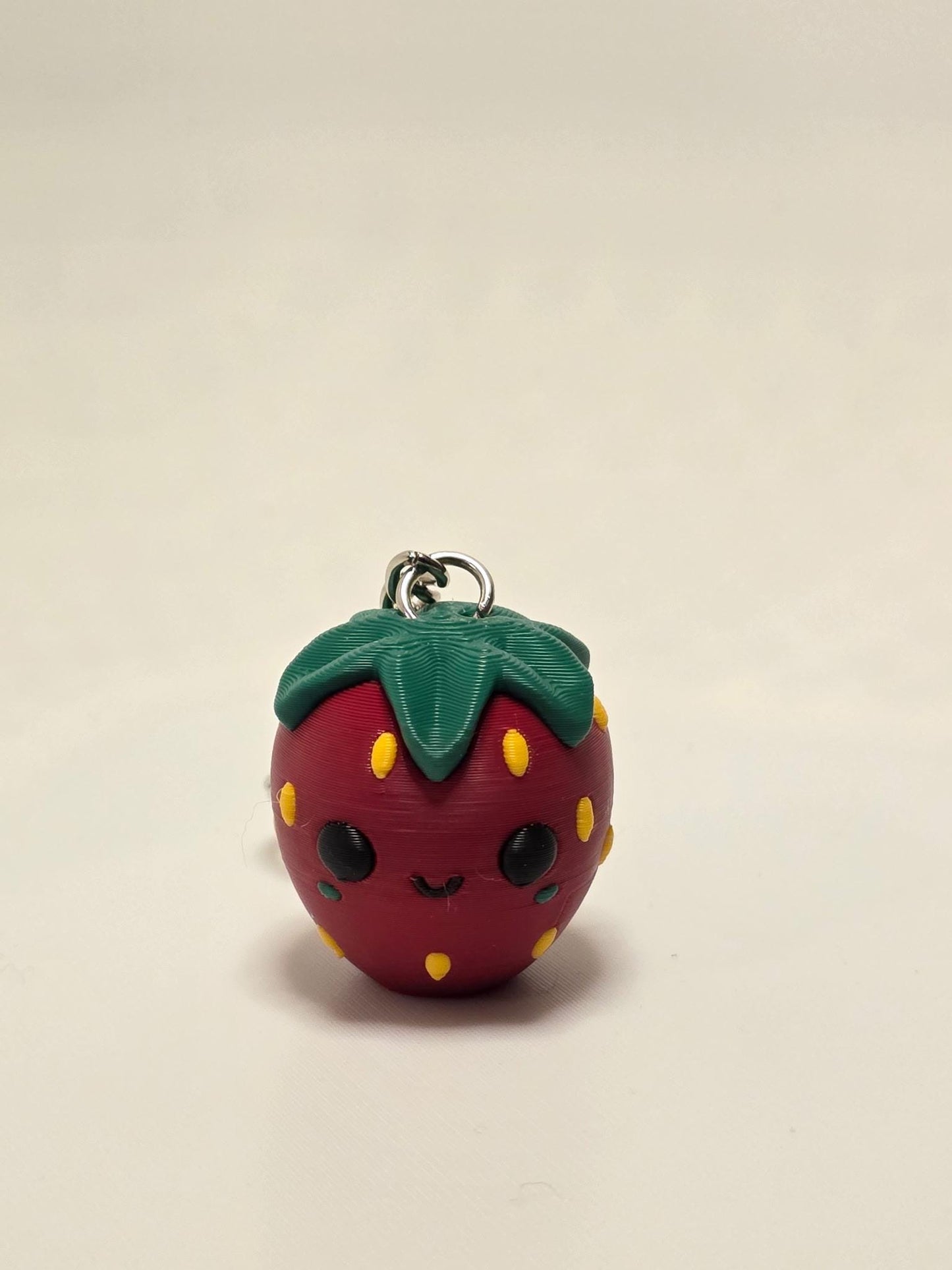 Cute HoneyBunny3D strawberry keychain attached to a bag, featuring a charming red and green strawberry charm accessory.